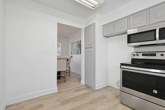 kitchen featuring stainless steel appliances, gray cabinets, and light hardwood / wood-style floors