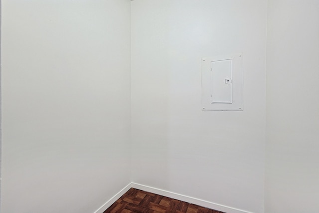 laundry room with electric panel and dark parquet floors