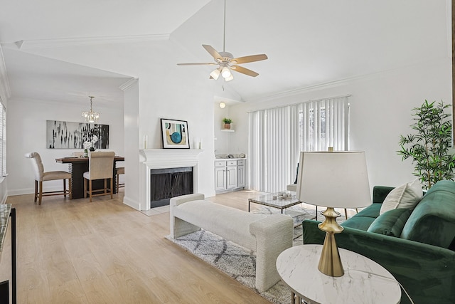 living room with ceiling fan with notable chandelier, crown molding, vaulted ceiling, and light wood-type flooring