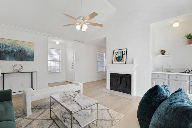 living room featuring vaulted ceiling, sink, ornamental molding, ceiling fan, and light hardwood / wood-style floors