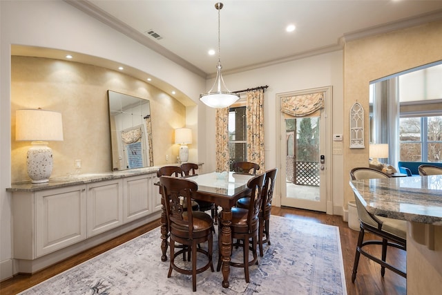 dining area featuring hardwood / wood-style flooring and crown molding