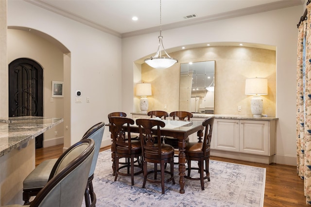 dining space with crown molding and light hardwood / wood-style flooring