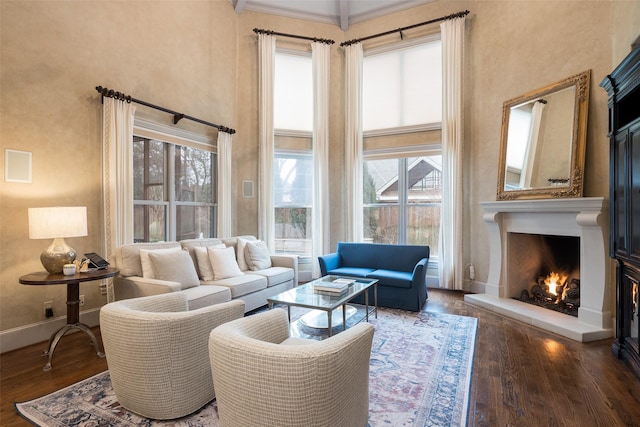 living room with crown molding, dark hardwood / wood-style floors, and a towering ceiling