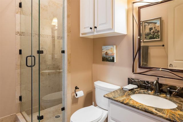 bathroom featuring an enclosed shower, vanity, and toilet