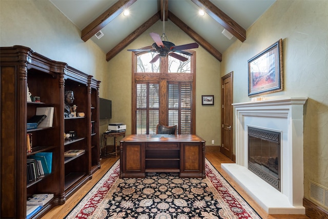 office space featuring ceiling fan, high vaulted ceiling, light hardwood / wood-style floors, and beamed ceiling