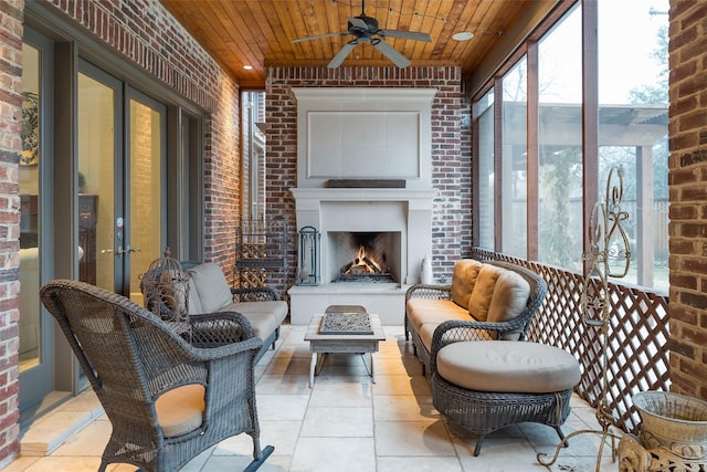 sunroom / solarium with exterior fireplace, wood ceiling, and ceiling fan