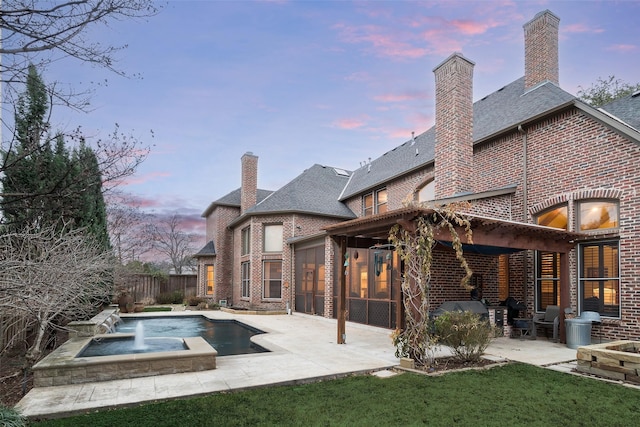 back house at dusk featuring a patio, a sunroom, pool water feature, and a fenced in pool