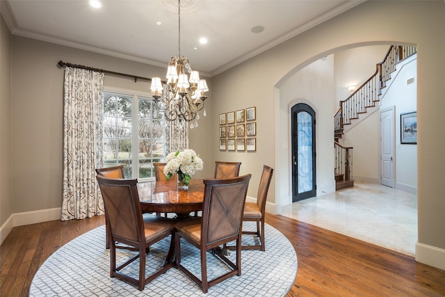 dining area with ornamental molding, an inviting chandelier, and dark hardwood / wood-style flooring