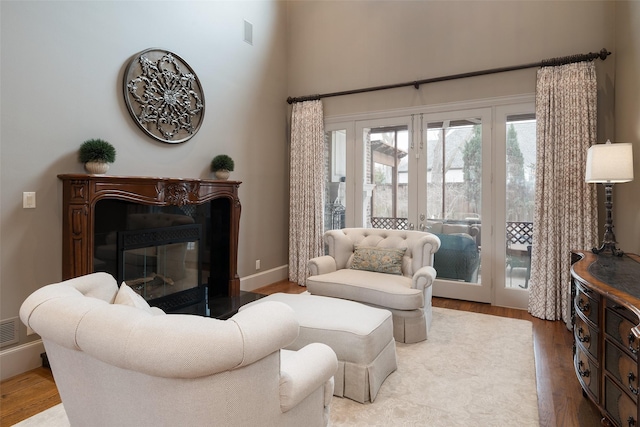 living room featuring french doors, a fireplace, and hardwood / wood-style flooring