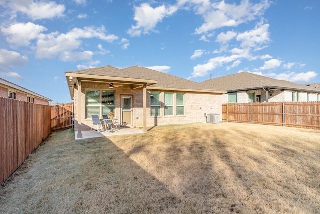 rear view of property featuring cooling unit, ceiling fan, a yard, and a patio area