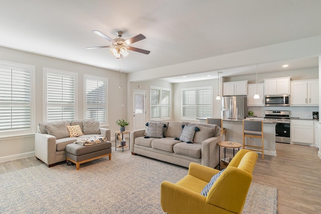 living room featuring ceiling fan and light wood-type flooring