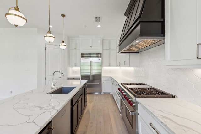 kitchen featuring white cabinetry, high quality appliances, sink, and premium range hood