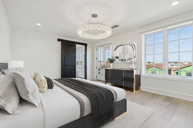 bedroom with light hardwood / wood-style floors and multiple windows