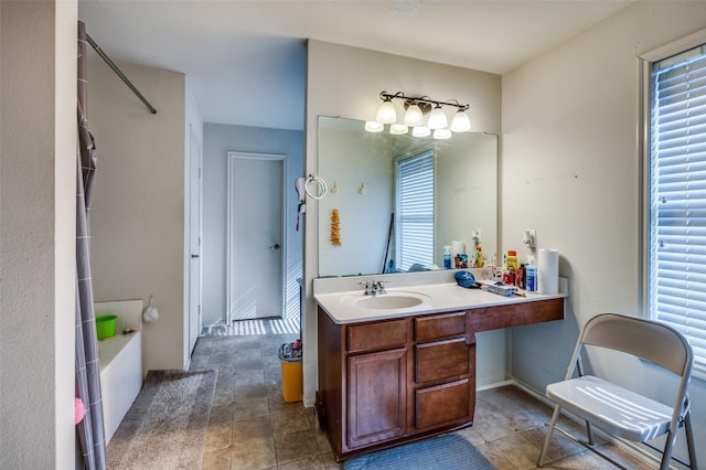 bathroom featuring vanity, a wealth of natural light, and a tub to relax in