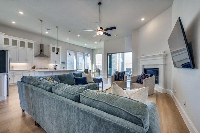 1154 20th St, Northlake, TX 76226 - living area with ceiling fan, baseboards, a glass covered fireplace, recessed lighting, and light wood-style flooring