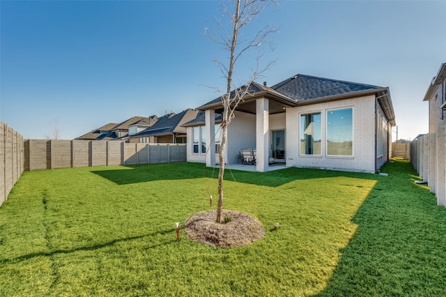 1154 20th St, Northlake, TX 76226 - back of house featuring a shingled roof, brick siding, a fenced backyard, a lawn, and a patio