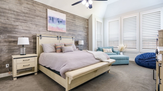 carpeted bedroom featuring ceiling fan, wooden walls, and vaulted ceiling