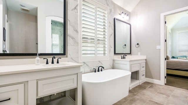 bathroom featuring a tub to relax in, vanity, tile walls, and a wealth of natural light