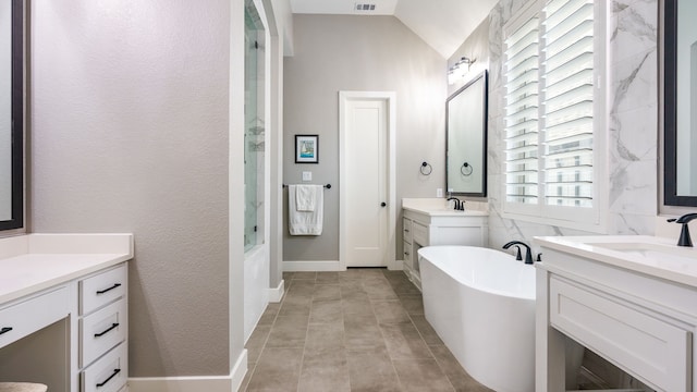 bathroom featuring lofted ceiling, vanity, and a bathtub