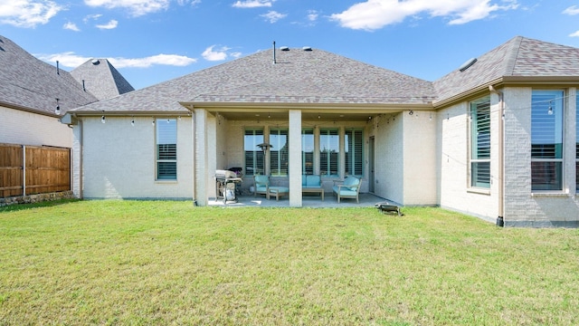 rear view of property featuring a yard, an outdoor hangout area, and a patio area