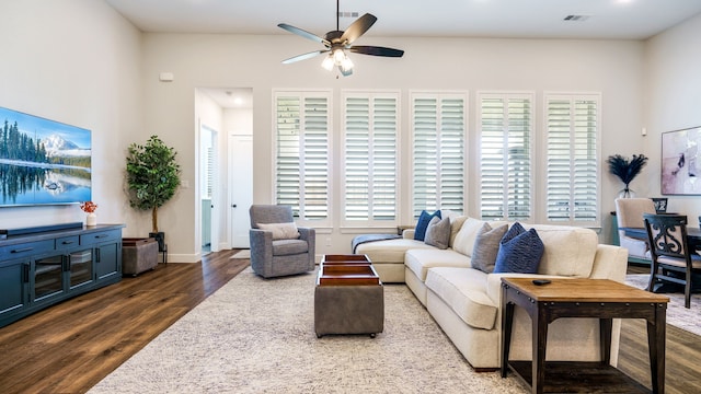 living room with dark wood-type flooring and ceiling fan