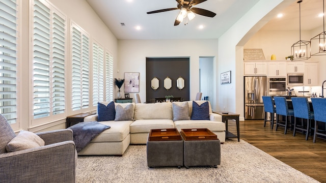 living room with ceiling fan with notable chandelier and wood-type flooring