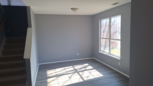 empty room with wood-type flooring and a wealth of natural light