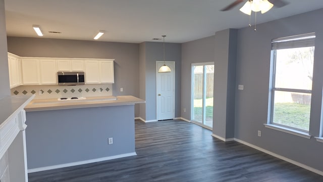 kitchen featuring pendant lighting, plenty of natural light, tasteful backsplash, and white cabinets