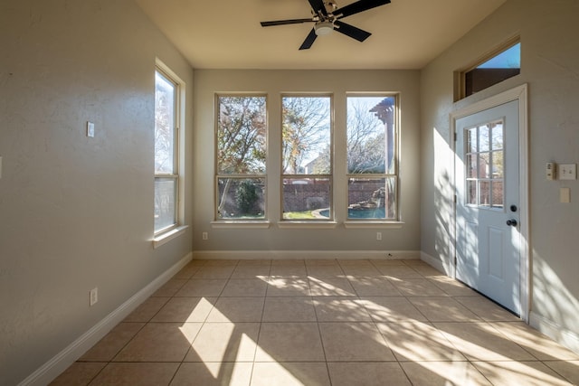 unfurnished sunroom with ceiling fan