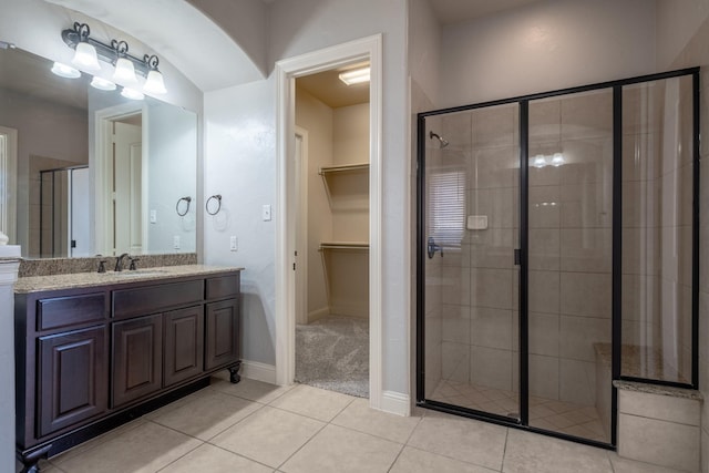 bathroom featuring walk in shower, tile patterned floors, and vanity