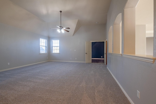 carpeted empty room featuring vaulted ceiling and ceiling fan