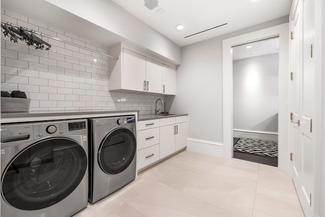 laundry area featuring sink, washer and clothes dryer, and cabinets