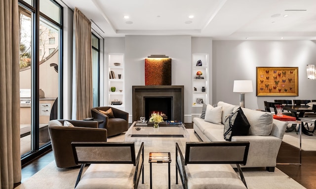 living room featuring wood-type flooring and built in features