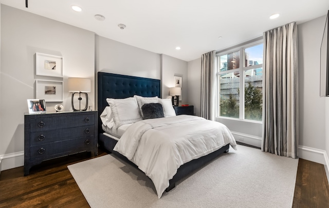 bedroom with dark wood-type flooring and multiple windows