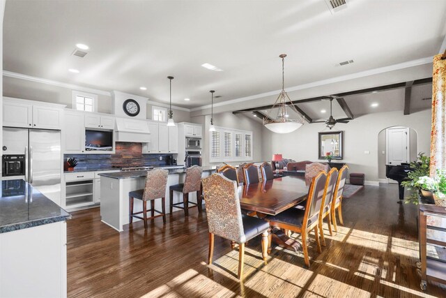 dining area featuring beamed ceiling, dark hardwood / wood-style flooring, ceiling fan, crown molding, and french doors