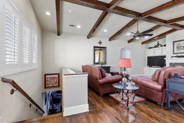 living room featuring beamed ceiling, ceiling fan, and dark hardwood / wood-style flooring