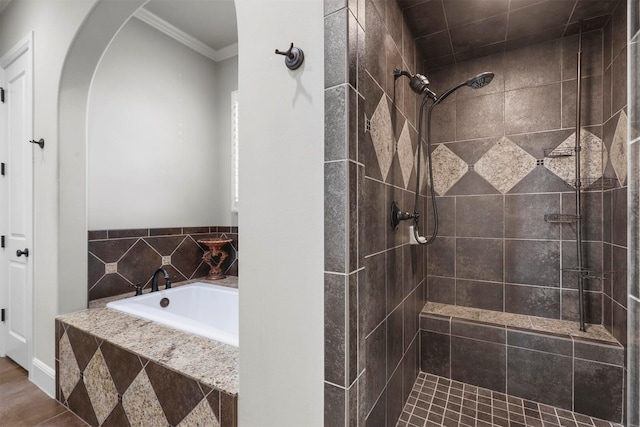 bathroom featuring ornamental molding and separate shower and tub