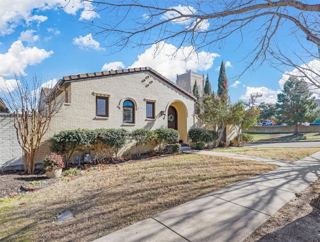 mediterranean / spanish home featuring a front lawn