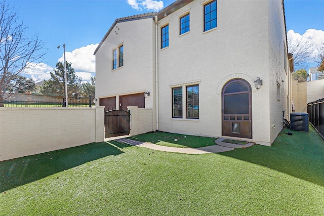 rear view of property with cooling unit and a lawn