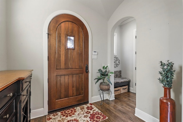 foyer entrance with dark wood-type flooring and lofted ceiling