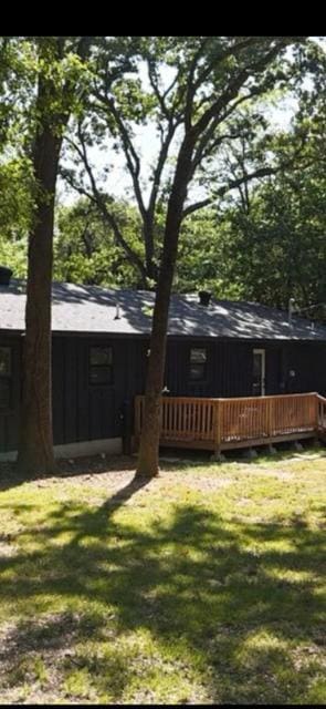 back of house with a wooden deck and a yard