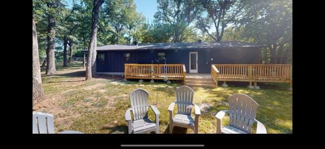 rear view of property with a yard and a deck