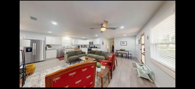 living room featuring ceiling fan and light hardwood / wood-style floors