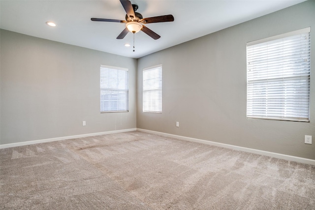 carpeted spare room featuring ceiling fan