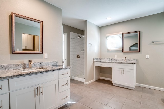 bathroom with vanity, a tile shower, and tile patterned floors