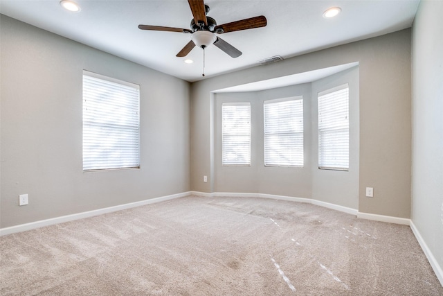 spare room with a healthy amount of sunlight, light carpet, and ceiling fan