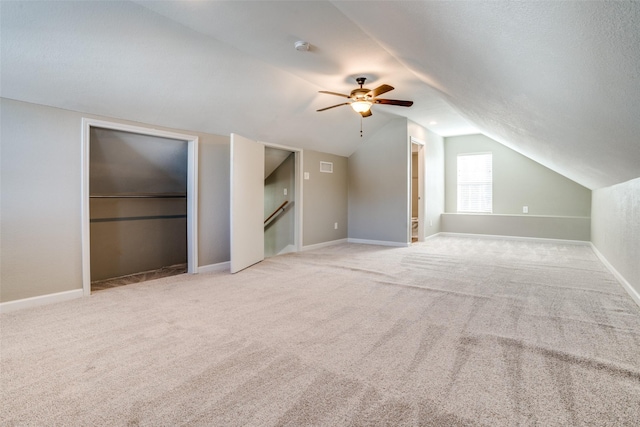 additional living space featuring ceiling fan, lofted ceiling, and light carpet