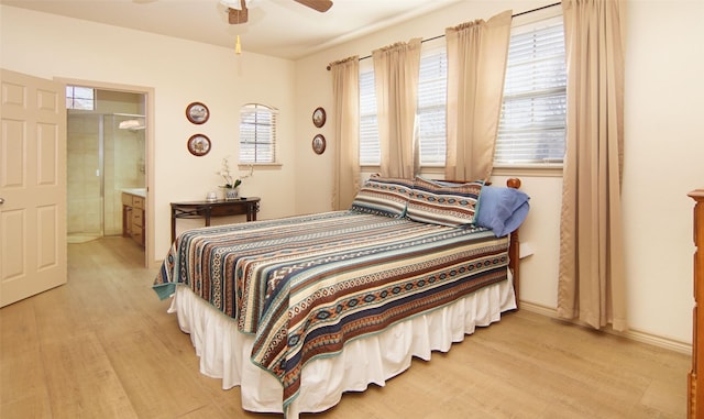 bedroom with ceiling fan, ensuite bath, and light hardwood / wood-style flooring