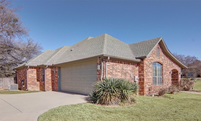 view of front of property featuring a garage, central AC unit, and a front yard