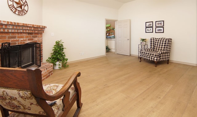 sitting room featuring a brick fireplace and light hardwood / wood-style floors